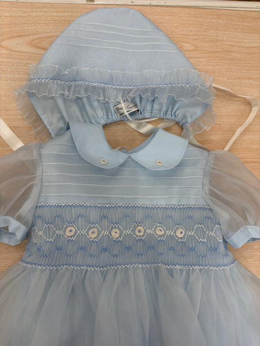 Abito Piccola Giuggiola in organza in seta celeste mezza manica con lavorazione di punto smock e lavorazione di fiori con cuffietta abbinata