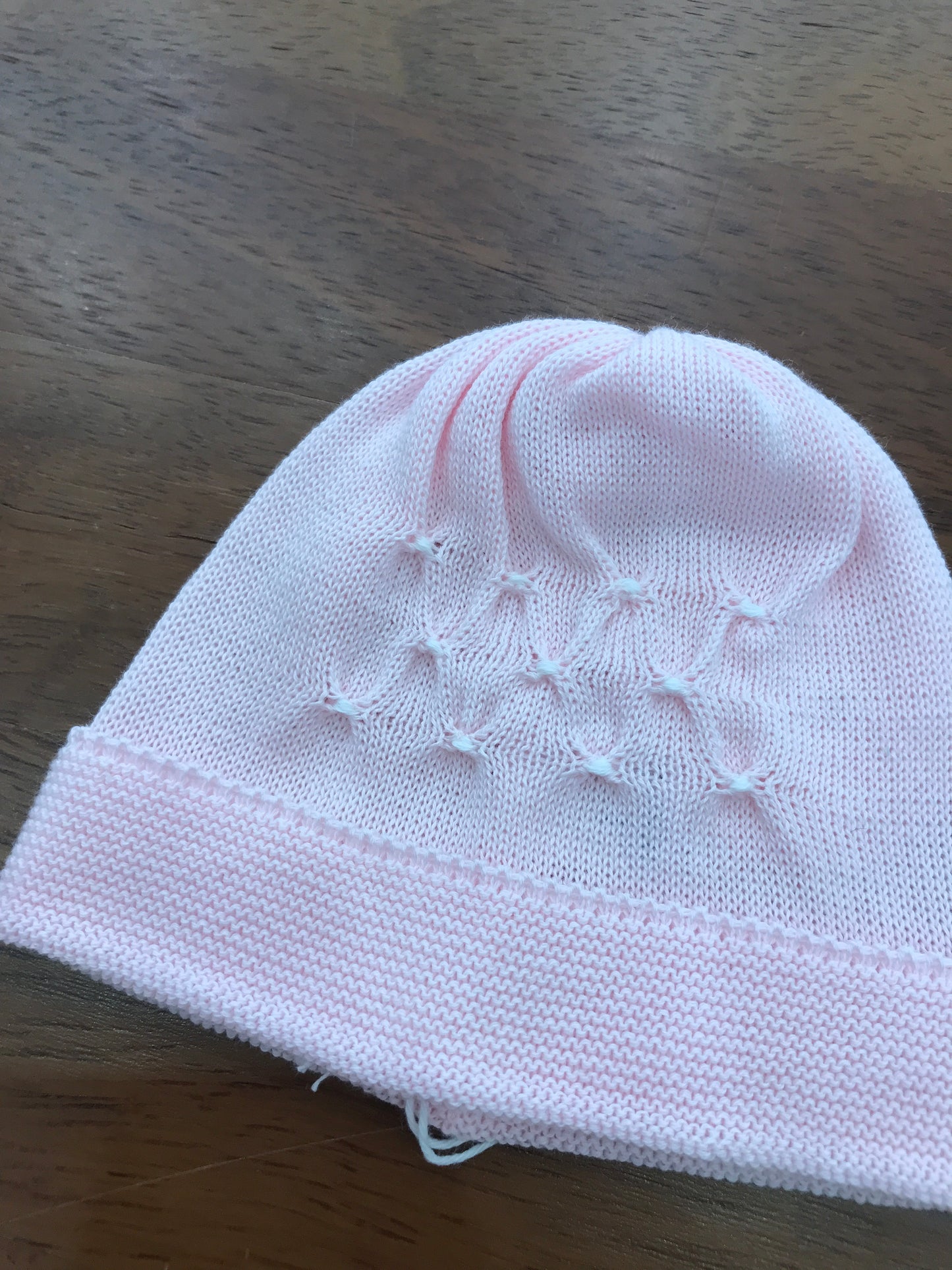 Cappello Baby Lord in filo rosa con risvolto con lavorazione di punto smock in bianco
