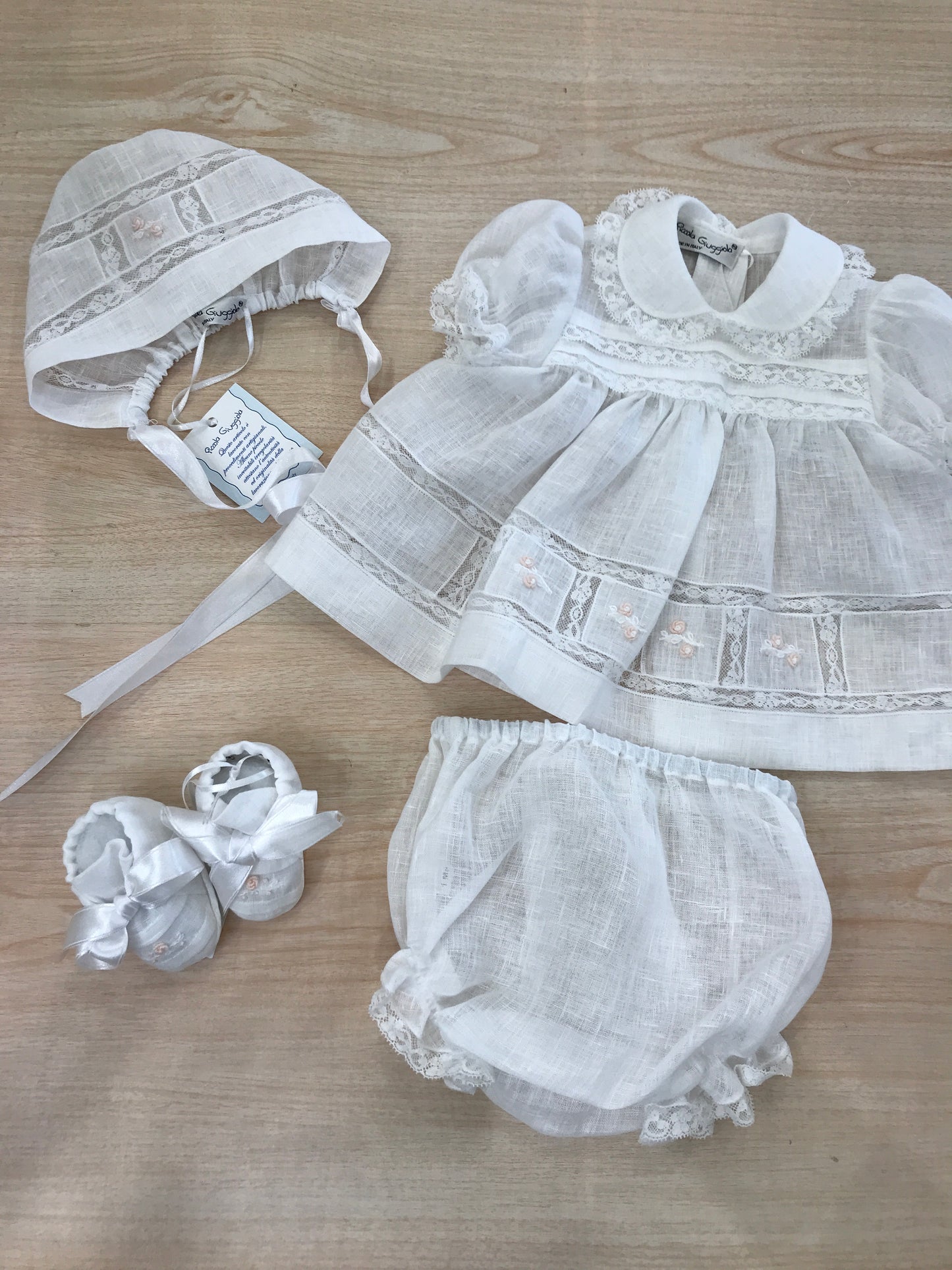 Coordinato Piccola Giuggiola in lino abitino con lavorazioni in pizzo e roselline ricamate con culotte cuffia e scarpine coordinate