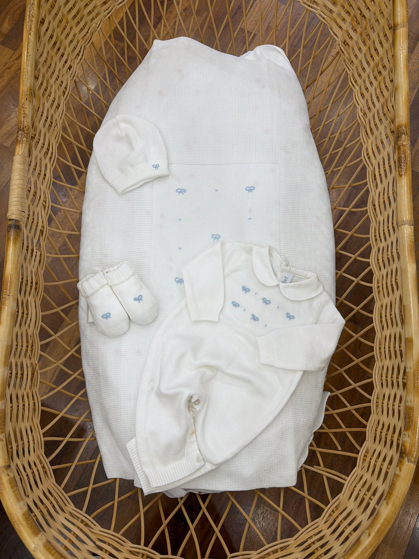 Coordinato nascita Pepecè in filo bianco con tanti piccoli fiocchetti ricamati a mano celesti su coperta tutina cappello e babbucce