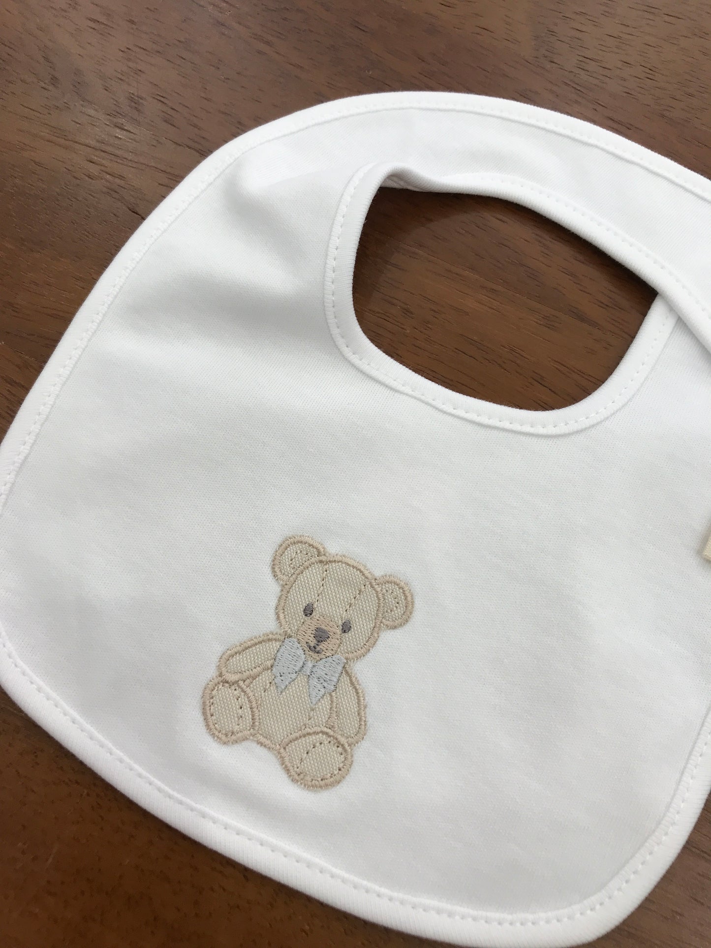 Bavetta Baby Gi in cotone bianco con orsetto ricamato sul davanti con fiocco grigio