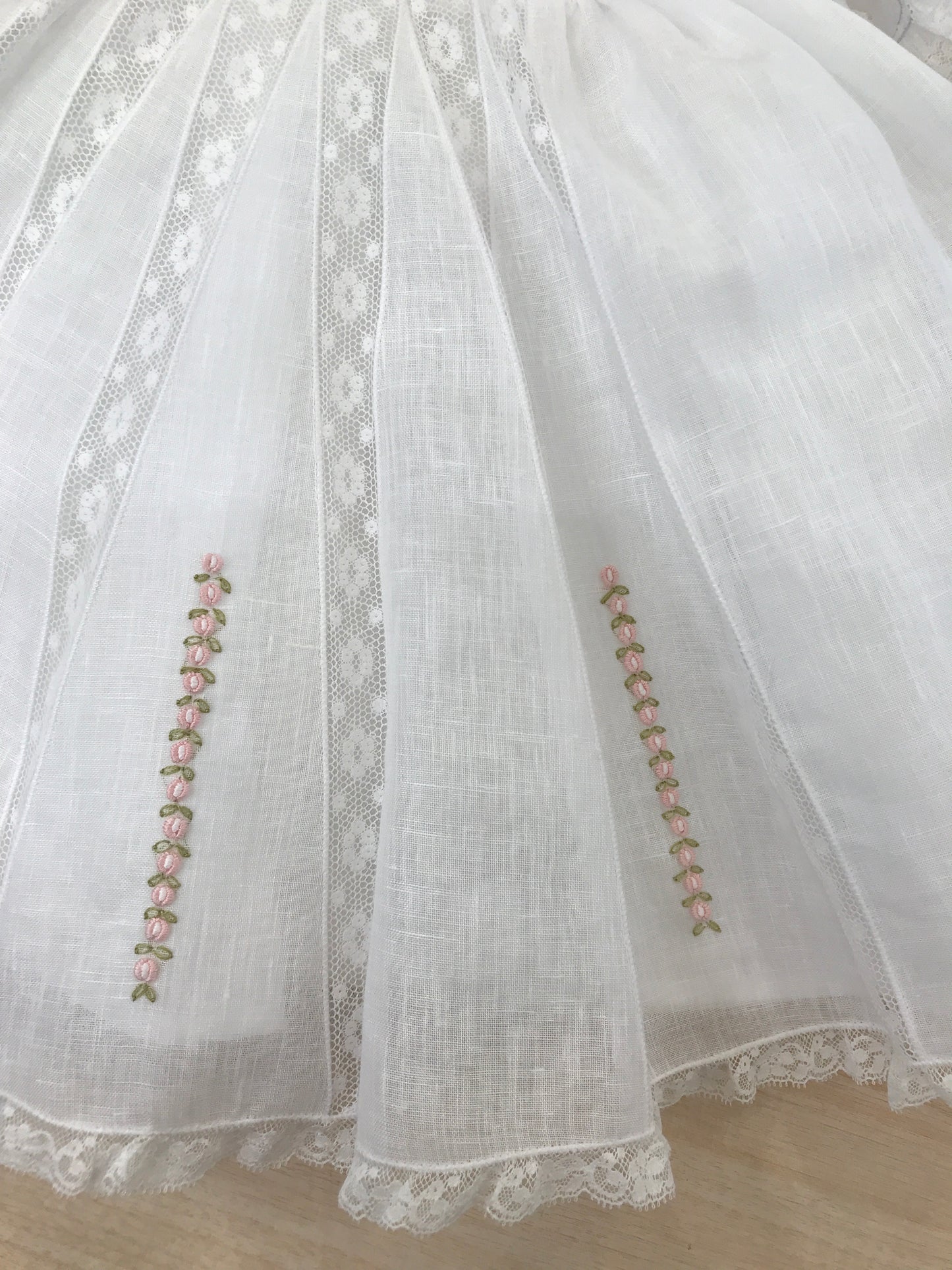 Abito Piccola Giuggiola in lino bianco corpetto lavorato con inserti di valancienne roselline rosa ricamate sulla gonna a ruota mezza manica e colletto rifinito anch'essi da valancienne
