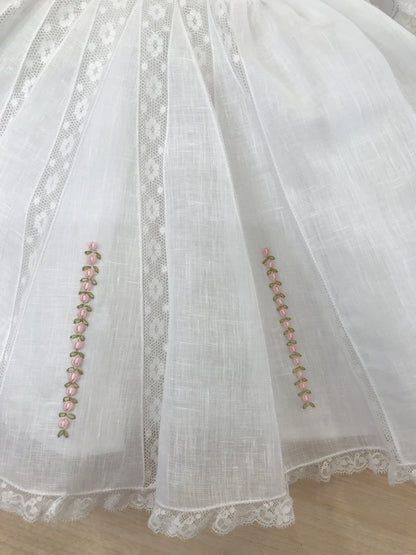 Abito Piccola Giuggiola in lino bianco corpetto lavorato con inserti di valancienne roselline rosa ricamate sulla gonna a ruota mezza manica e colletto rifinito anch'essi da valancienne