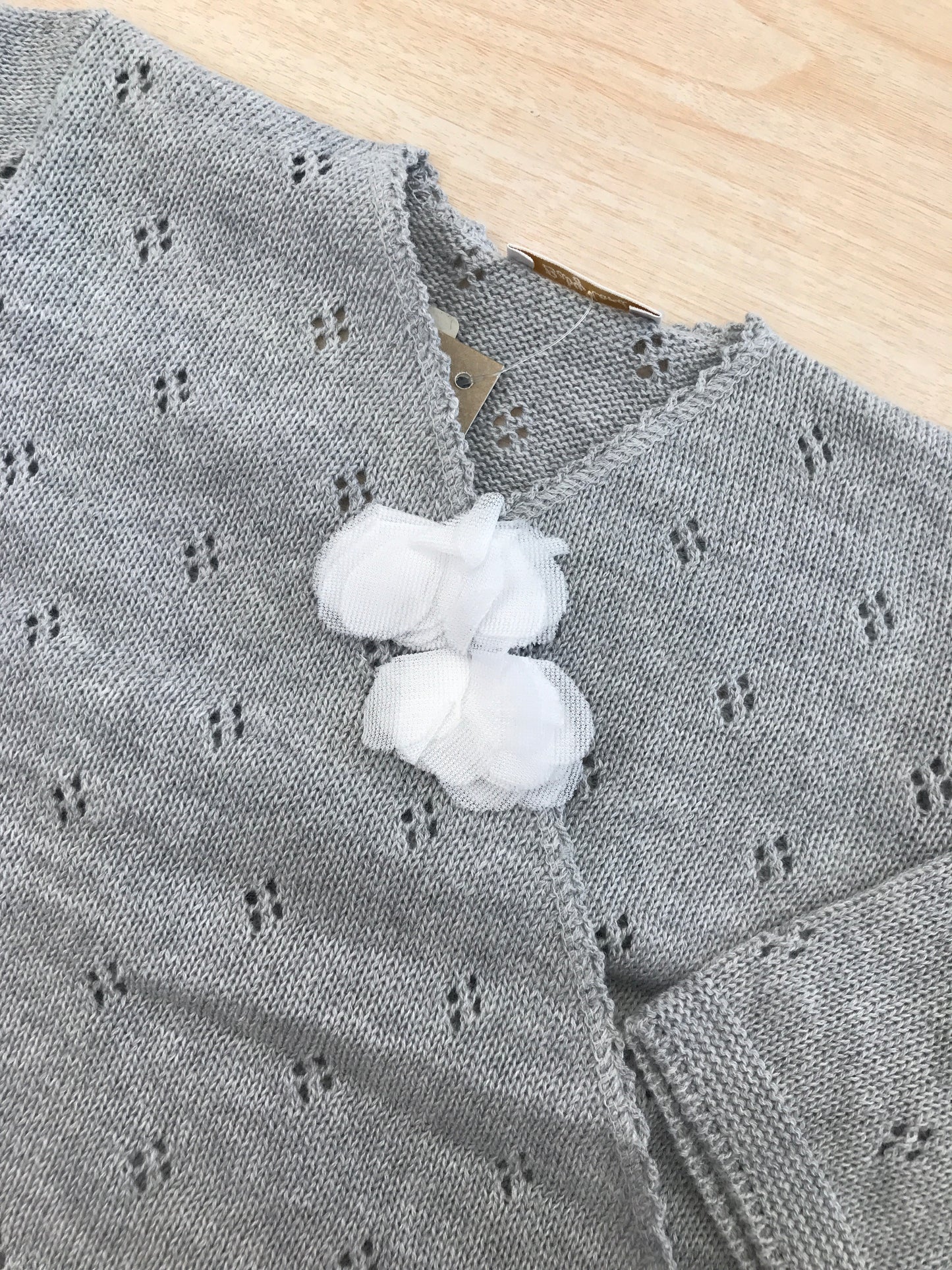 Cardigan Baby Lord in filo grigio ad incrocio traforato con due fiori sul davanti