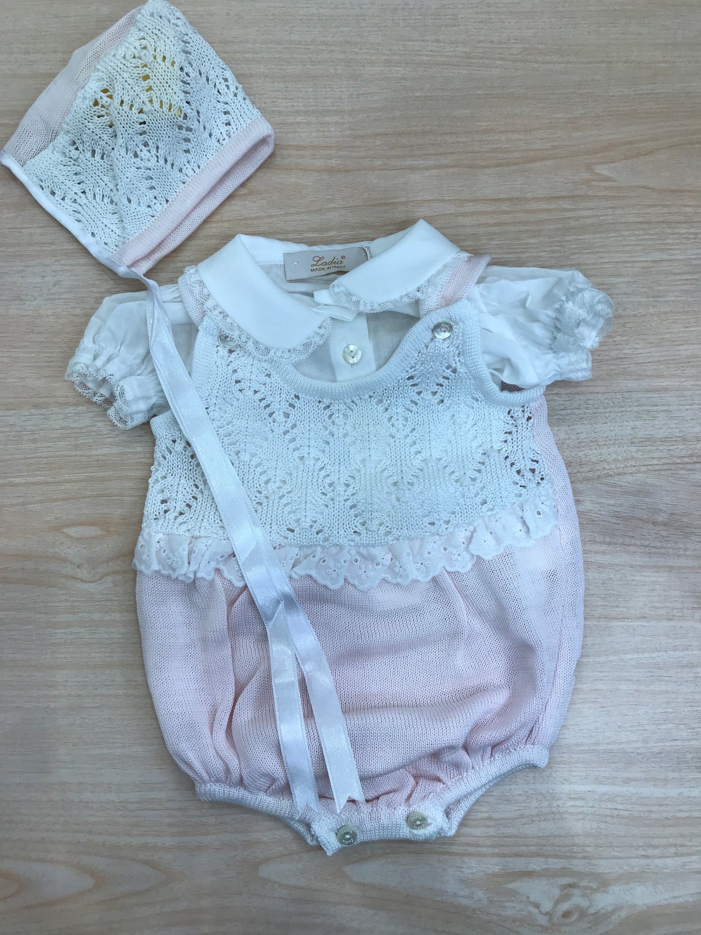 Pagliaccetto Ladia in filo traforato in rosa e bianco con camicina abbinata a sbuffo e cuffietta bianca e rosa traforata con laccio