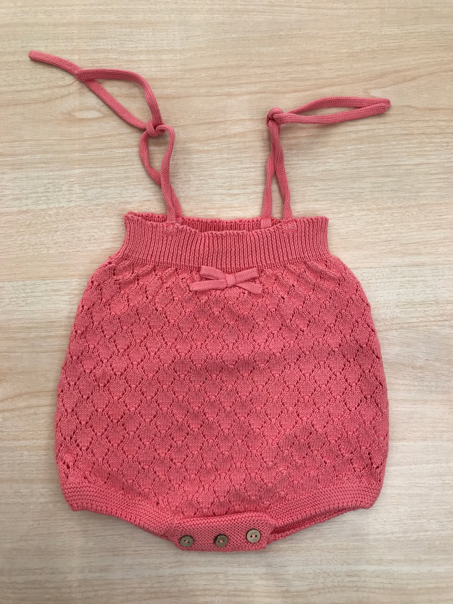 Salopette PCS in filo corallo  lavorata a maglia con fiocchetto sul davanti con bretelle regolabili