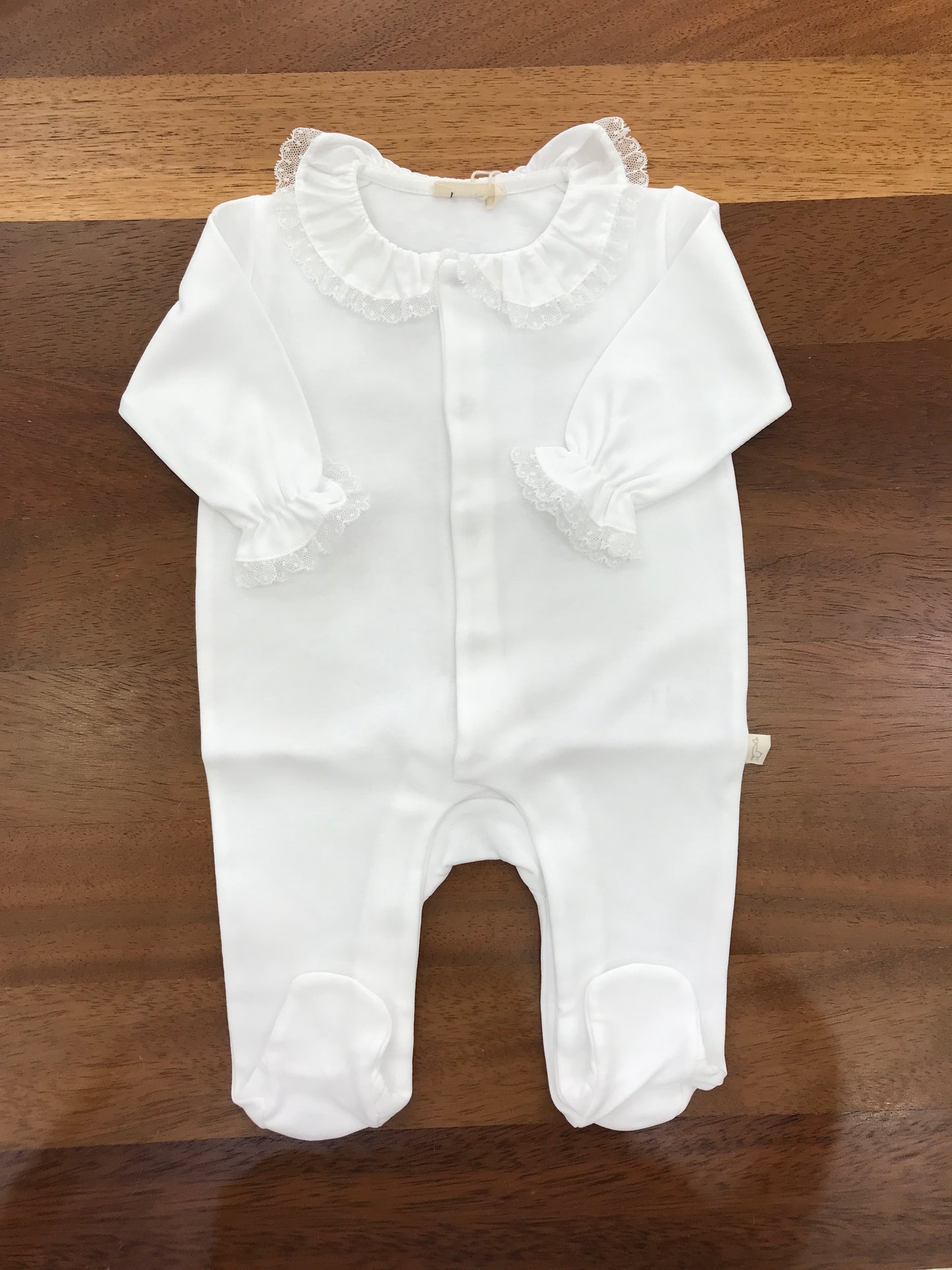 Tutina Baby Gi in cotone bianco manica lunga gamba lunga con piedini con collo con rusche rifinita da pizzo