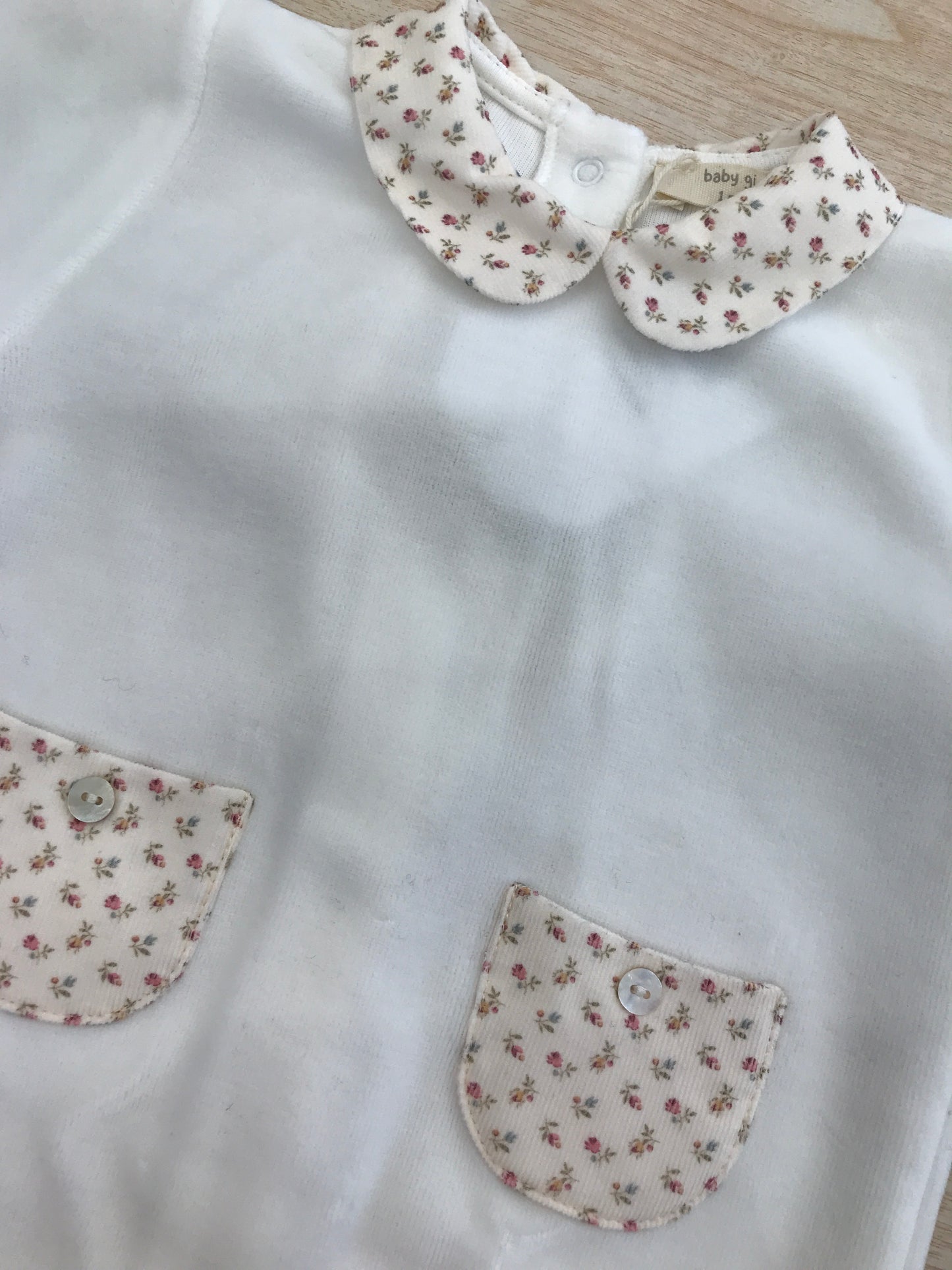 Tutina Baby Gi in ciniglia intera con taschine e fiocchetto floreale sul davanti