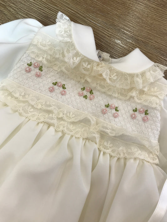 Abito Piccola Giuggiola in lana svizzera con pieghe sulla gonna manica lunga rifinita da valancienne corpetto lavorato da punto smock con roselline e colletto tondo coordinato con cuffia e scarpine con stesso tono e stessi dettagli