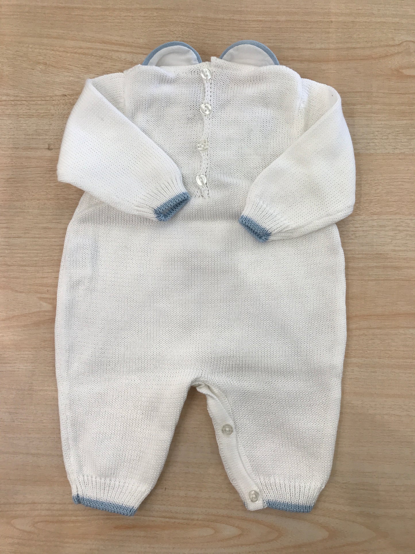 Tutina Bebè di Almy in filo bianco con rifiniture celesti con lavorazione id punto smock sul corpetto