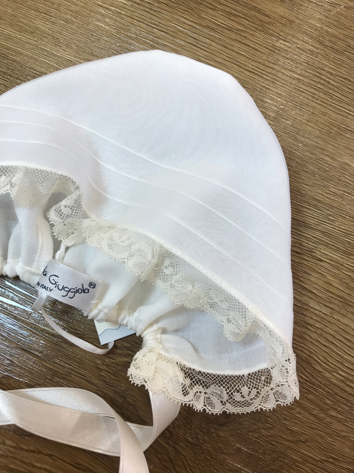 Cuffia Piccola Giuggiola in organza in seta panna con piccole pieghe e valancienne applicato sul davanti per incorniciare il piccolo visino