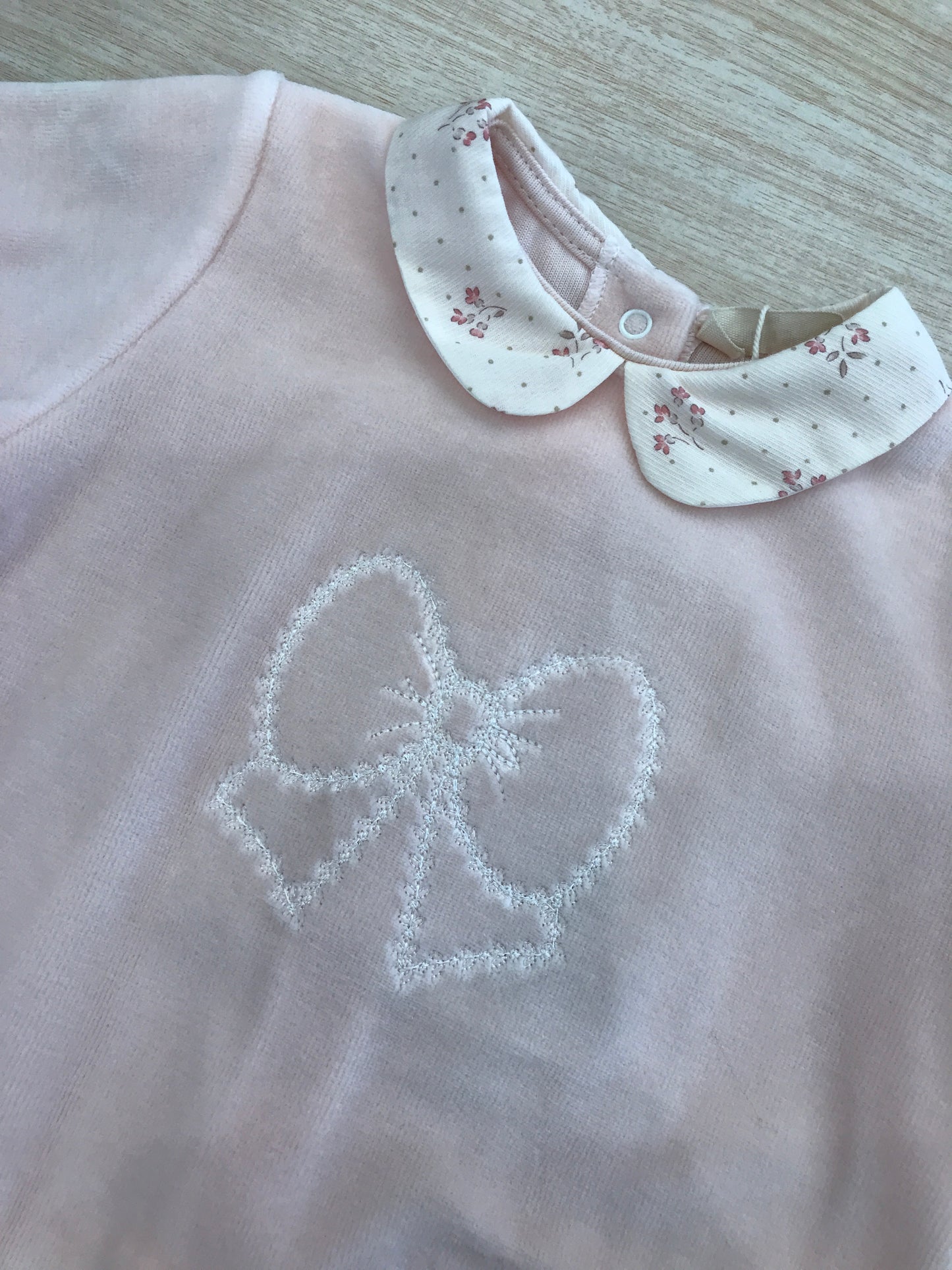 Tutina Baby Gi in ciniglia rosa pesca intera con fiocco ricamato al centro e colletto panna floreale