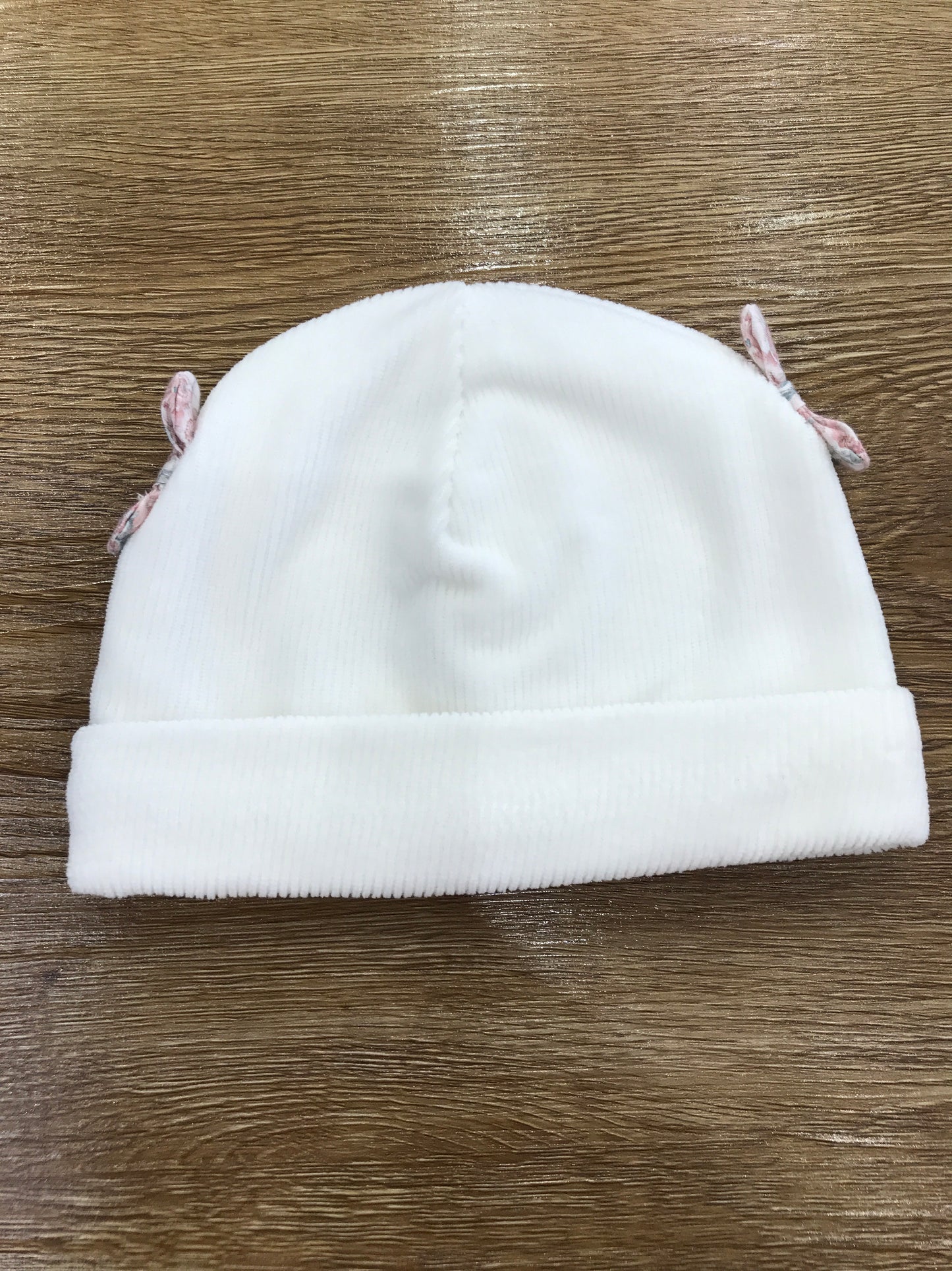 Cappello Nanan in ciniglia con risvolto e fiocchetti laterali con fiori