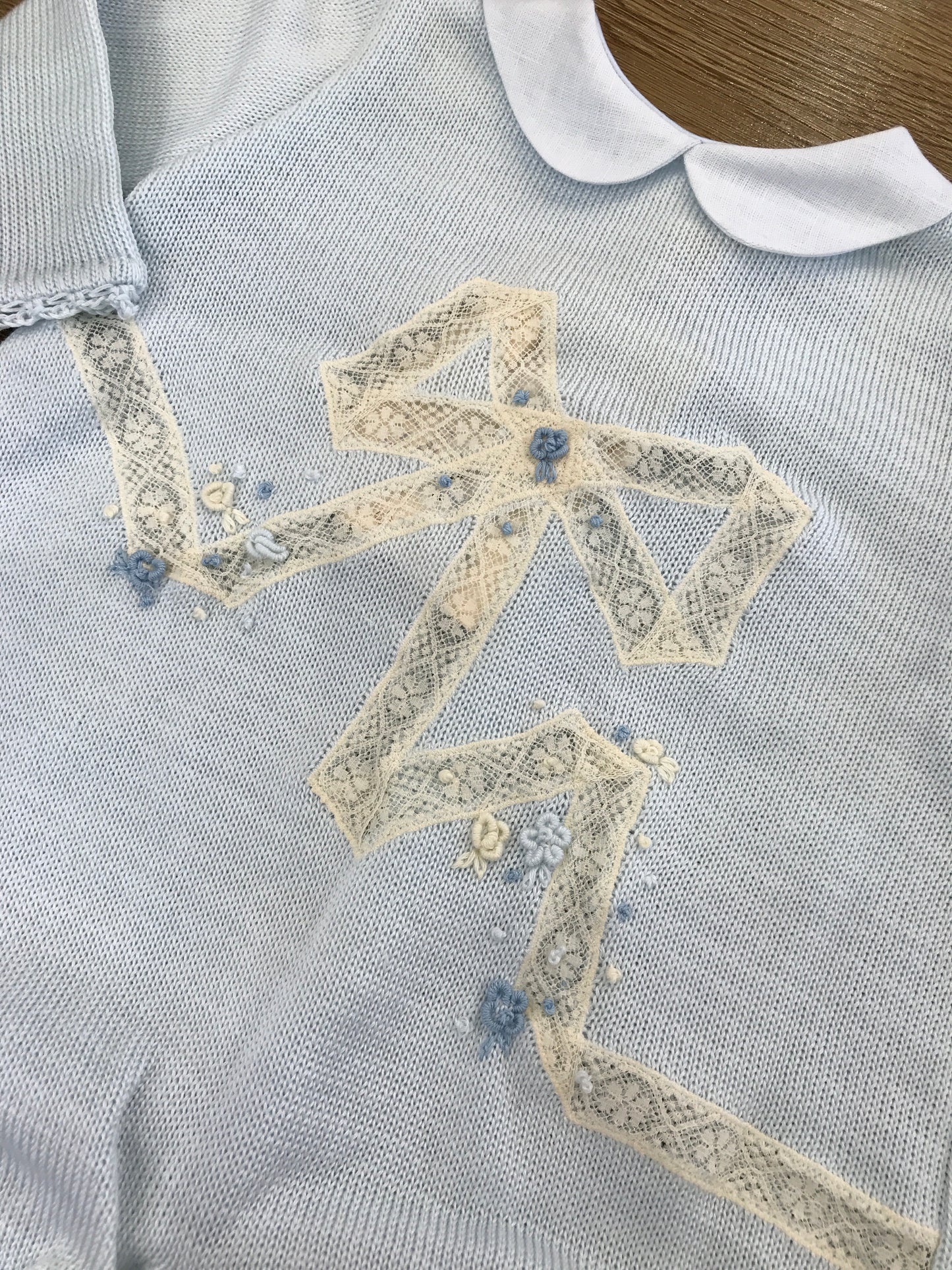 Tutina Ladia in filo di cotone celeste con fiocco ricamato da valancienne e roselline