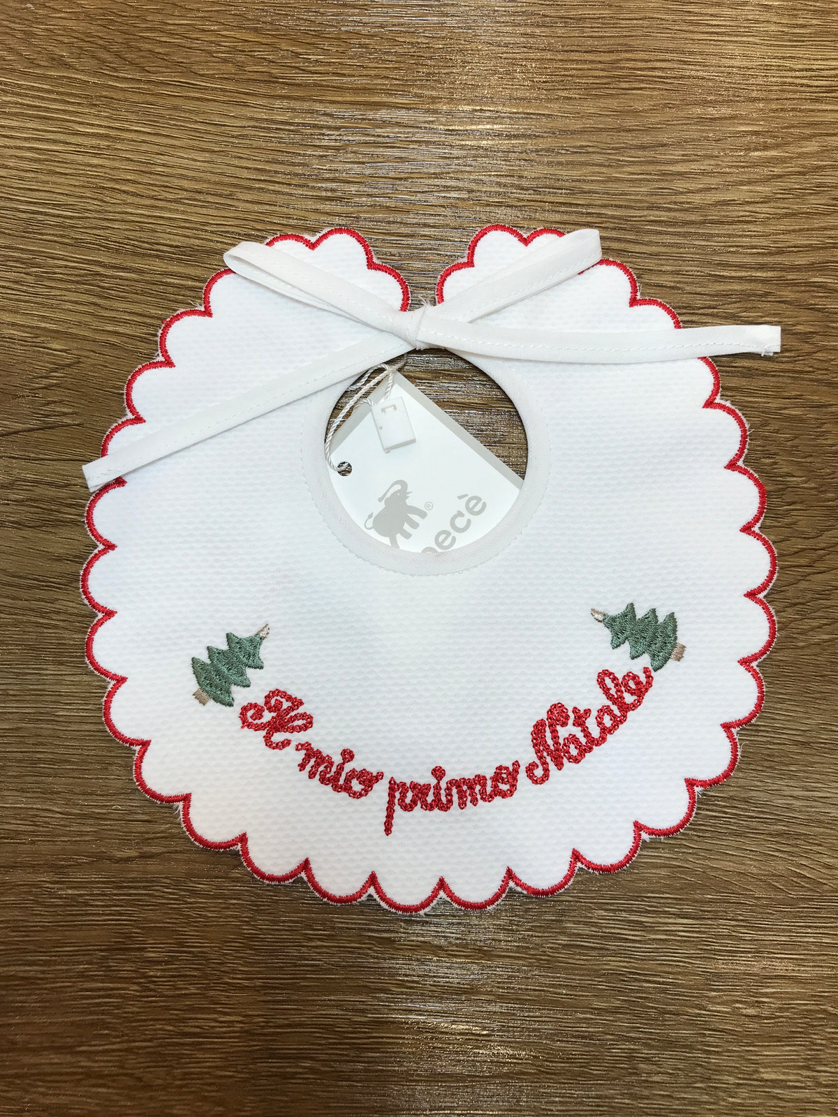 Bavetta Pepecè in piquet smerlata con profilo rosso e ricamo "il mio primo natale" con due alberelli laterali