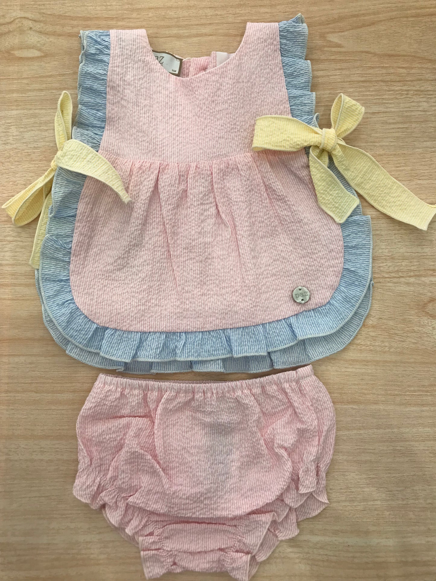 Completo Paz Rodriguez in cotone due pezzi casacca rosa con rusche celeste con fiocchi laterali gialli culotte abbinata in rosa