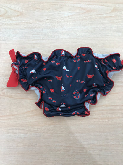 Costume Paz Rodriguez con rusche blu scuro con piccoli disegnini con fiocchetti rossi laterali