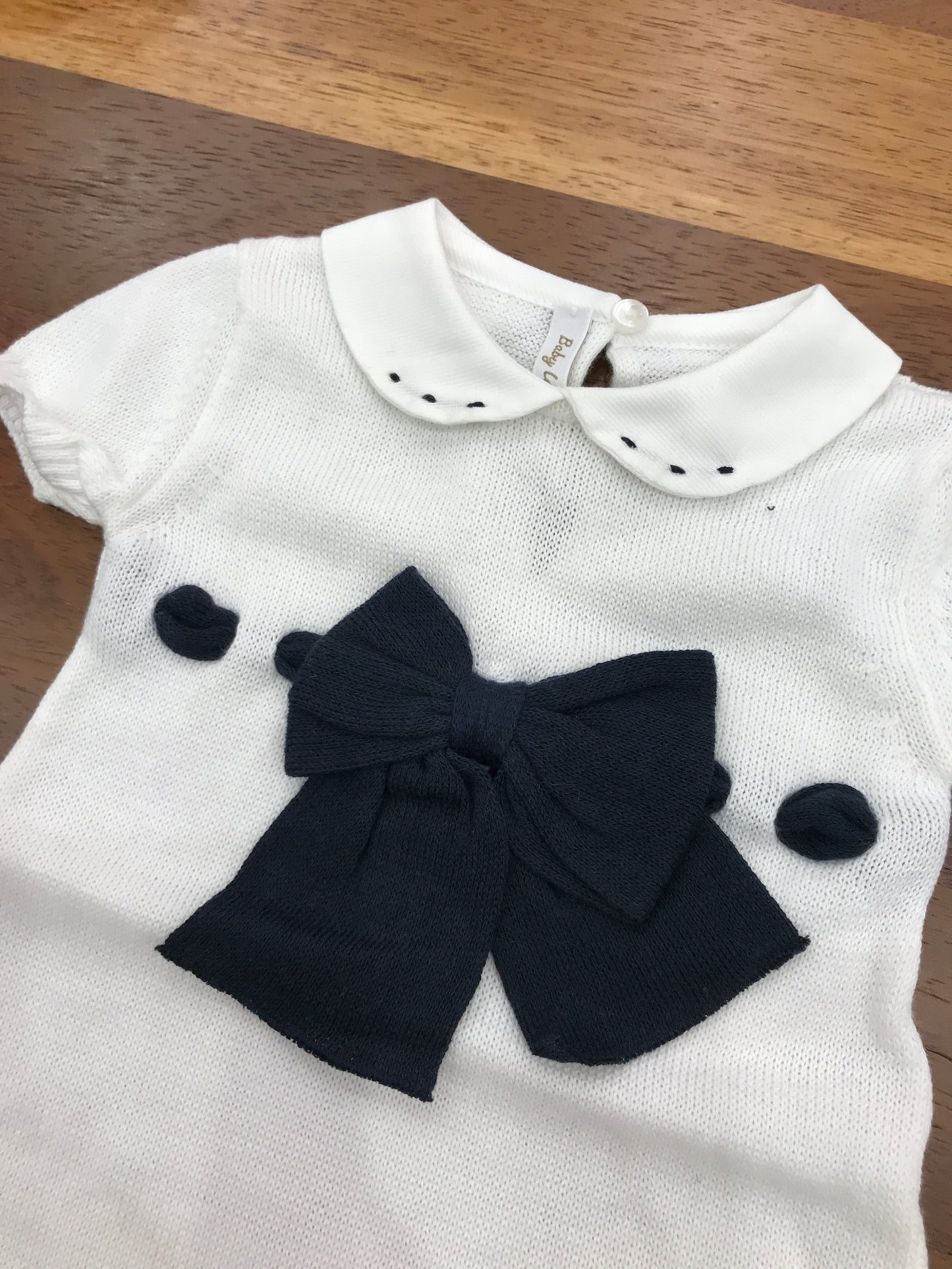 Pagliaccetto Baby Lord in filo bianco mezza manica con fiocco e passanastro blu con collo tondo bianco con pois blu