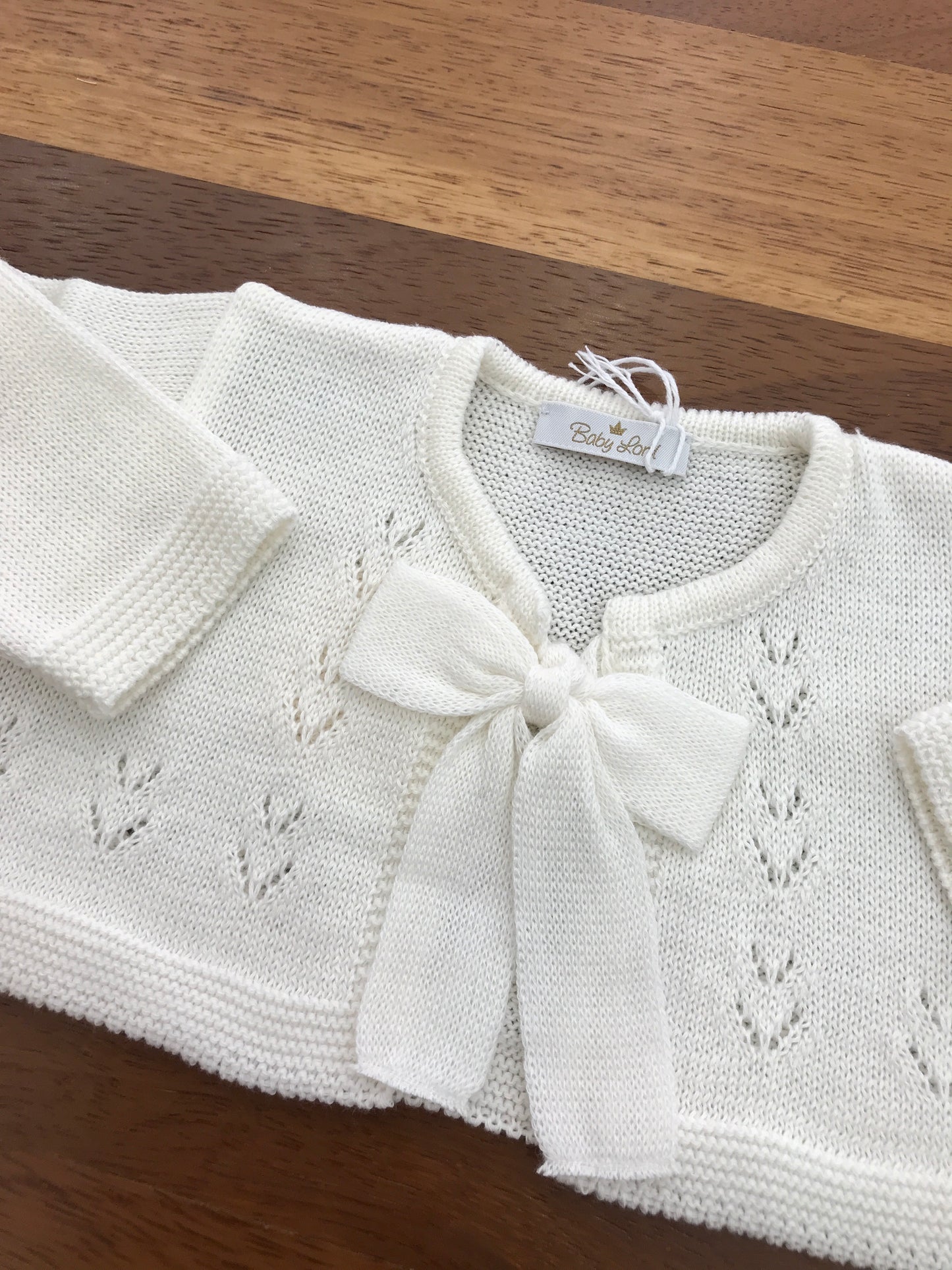Cardigan Baby Lord in filo panna manica lunga con fiocco e lavorazione sul davanti