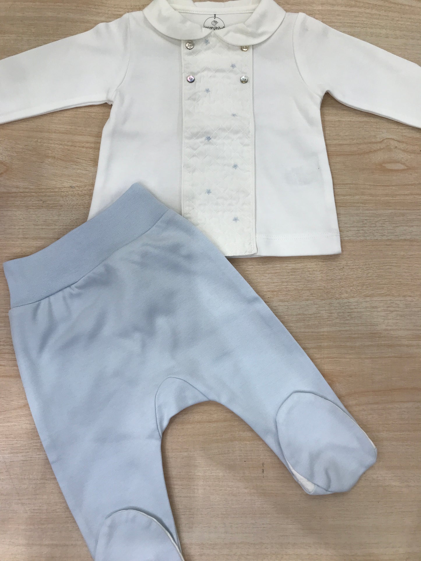 Tutina Laranjinha in cotone due pezzi bianco e celeste con piedi e dettagli sul davanti
