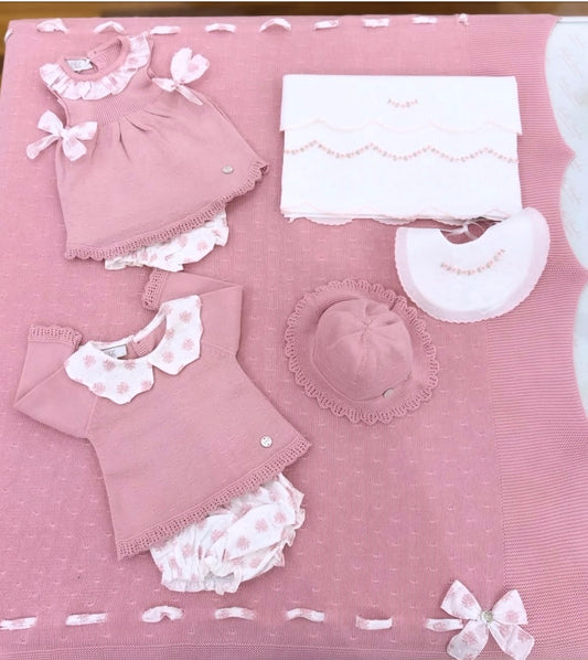 Coordinato nascita Paz Rodriguez per sorelline in tonalità rosa antico con dettagli in bianco con fiocchetti e fiori rosa